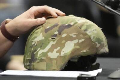 Nicole Herling, sister of shooter Robert Card II, rests her hand on her brother's military helmet, while testifying, Thursday, May 16, 2024, in Augusta, Maine, during a hearing of the independent commission investigating the law enforcement response to the mass shooting in Lewiston, Maine. (Robert F. Bukaty/AP)