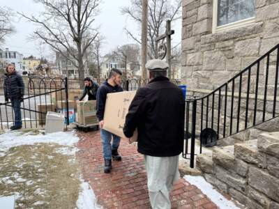 Afzal and his father move the family's belongings out of St. Paul's. (Lynn Jolicoeur/WBUR)