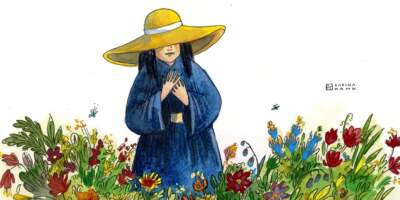 A farmer wearing a yellow hat in a field of flowers. (Sabina Hahn for WBUR)